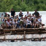 Gruppe von Menschen rutscht mit Floß die Isar entlang © KulturErben