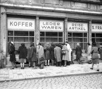 Menschen vor den Schaufenstern eines vollen Ladens