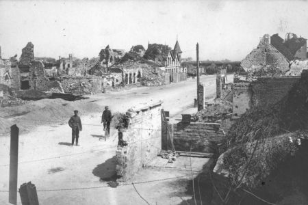 Soldaten gehen durch zerstörtes Dorf