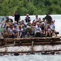 Gruppe von Menschen rutscht mit Floß die Isar entlang © KulturErben