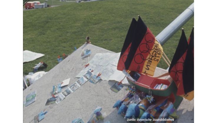 Foto von Deutschland-Fahnen und Werbeartikeln von den Olympischen Spielen 1972 in München © Bildarchiv der Bayerischen Staatsbibliothek/ Carsten de Riese