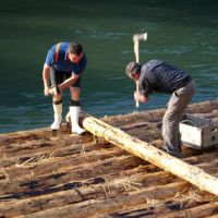 Zwei Arbeiter bauen das Floß zusammen