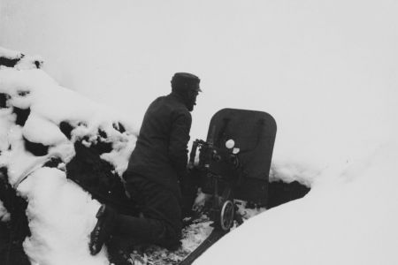 Mann mit Maschinengewehr im Schnee