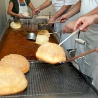 Fertig gebackener Hutkrapfen wird aus dem Öl genommen