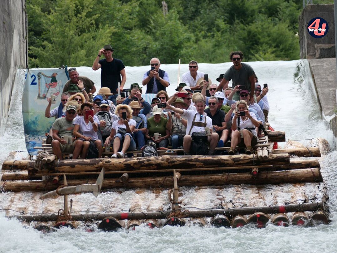 Gruppe von Menschen rutscht mit Floß die Isar entlang © KulturErben